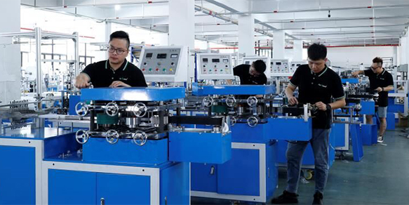 factory floor showing multiple cotton swab-making units in operation